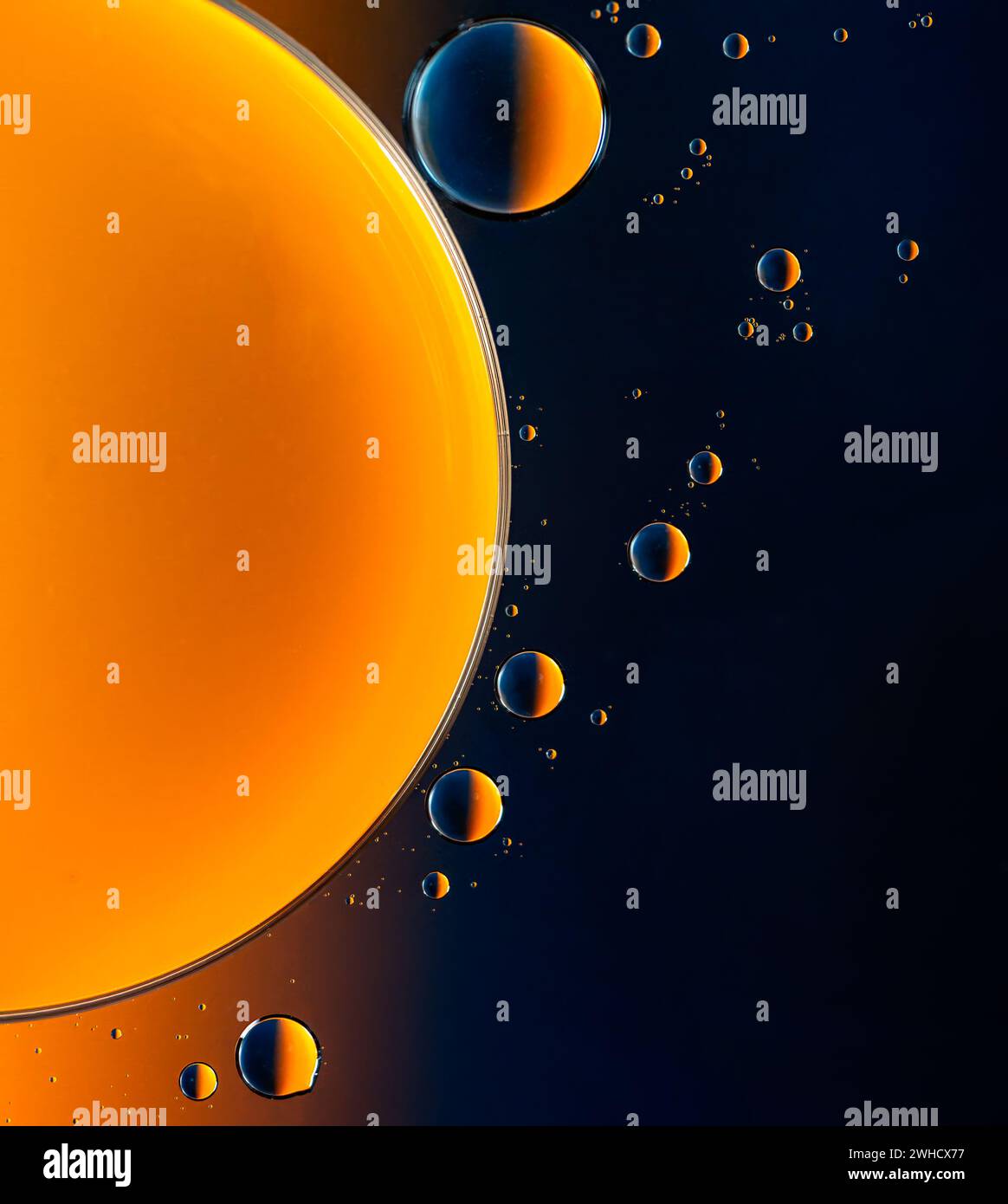 Abstract macro with oil drops in water, looking like planets in space. Stock Photo