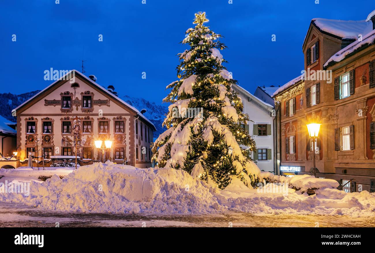 Snow-covered Christmas tree on the historic Ludwigstrasse in the Partenkirchen district at dusk, Garmisch-Partenkirchen, Loisachtal, Werdenfelser Stock Photo
