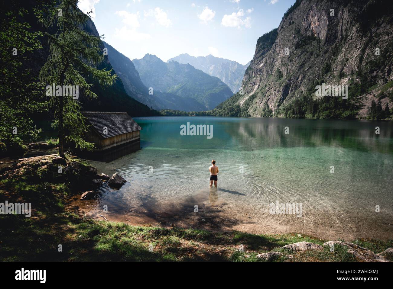 Man Standing Knee-deep In Water On The Shore Of The Obersee With A View 