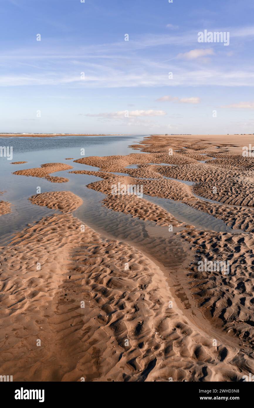 Onset of low tide on the North Sea island of Norderney, outgoing tide on the beach, ground-level perspective Stock Photo