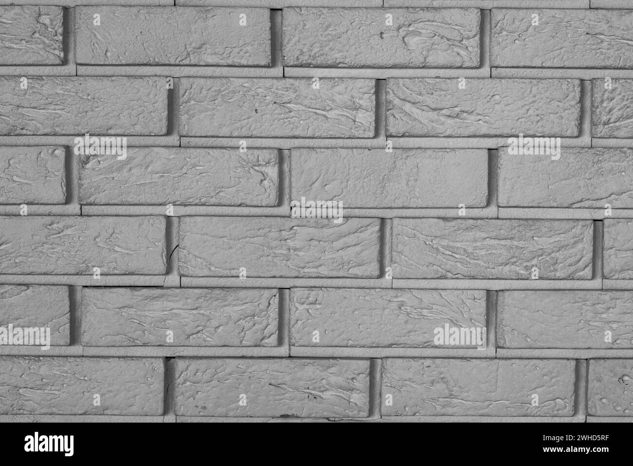 The texture is a dark brick wall. dark beautiful bricklaying. brickwork. abstract background. horizontal part of grey wall Stock Photo