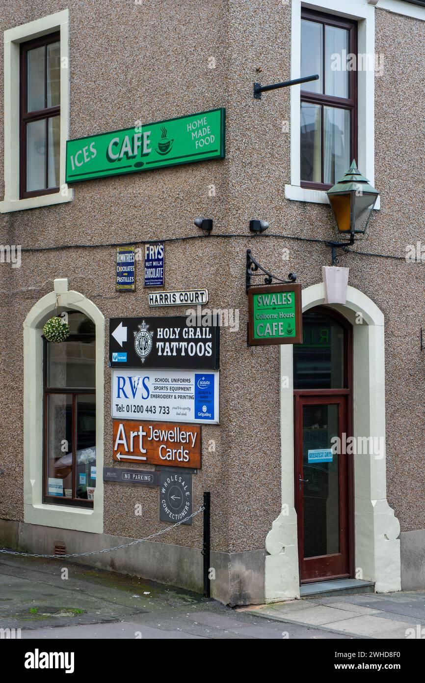 A proliferation of business signs old and new on the corner of a traditional Victorian building in a small market town Stock Photo