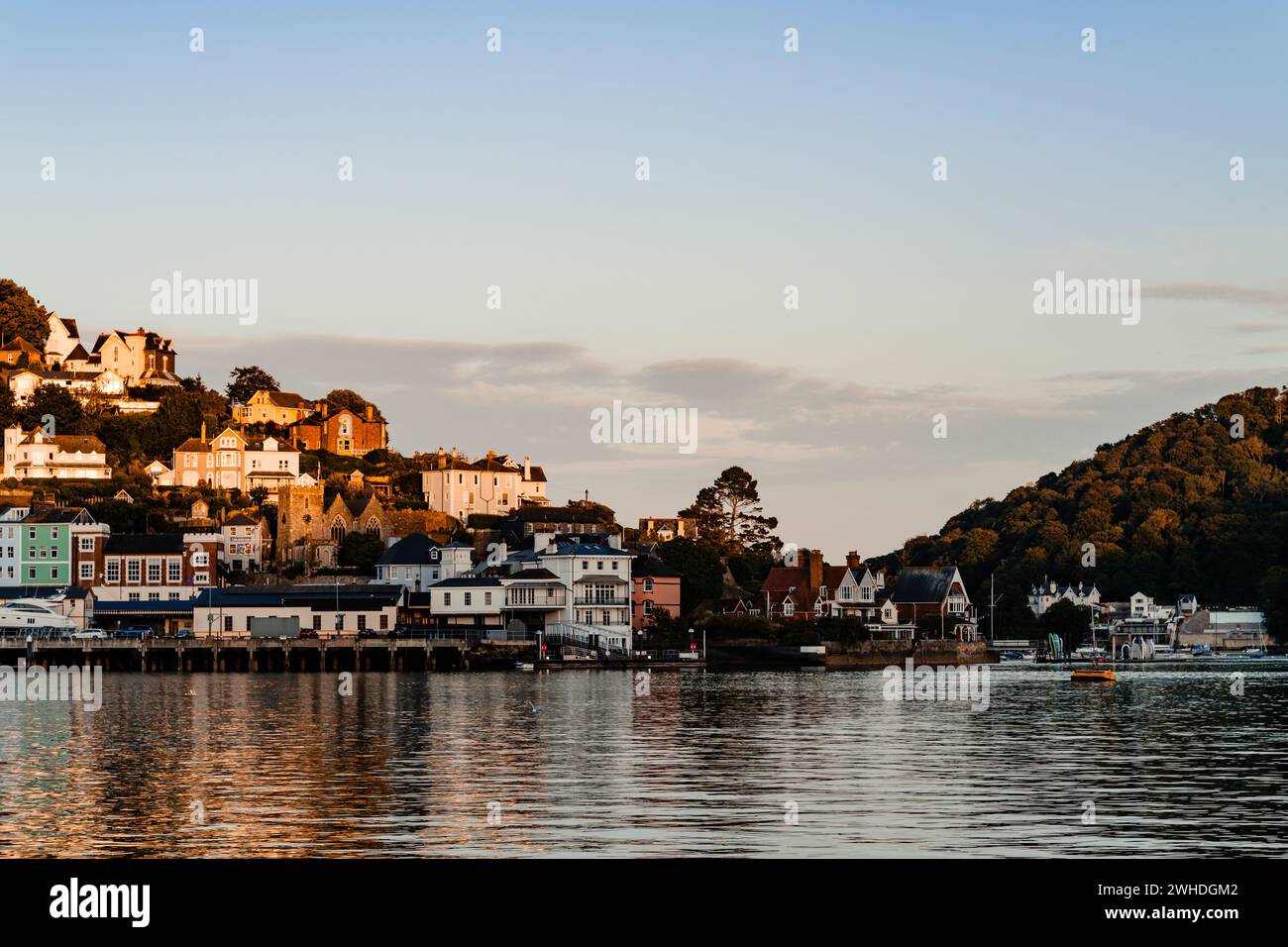 Evening atmosphere in the bay of the harbor town of Dartmouth, view of the town's houses reflected in the water Stock Photo