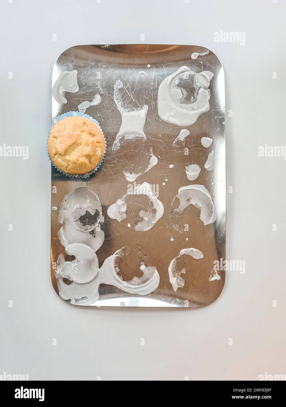 Silver tray with icing and the last cupcake left over Stock Photo
