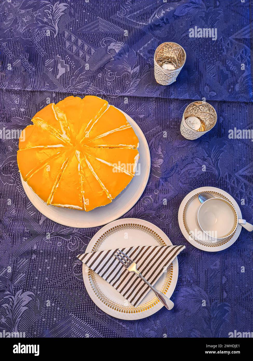 Festively laid table with birthday cake and crockery on a blue festive tablecloth Stock Photo