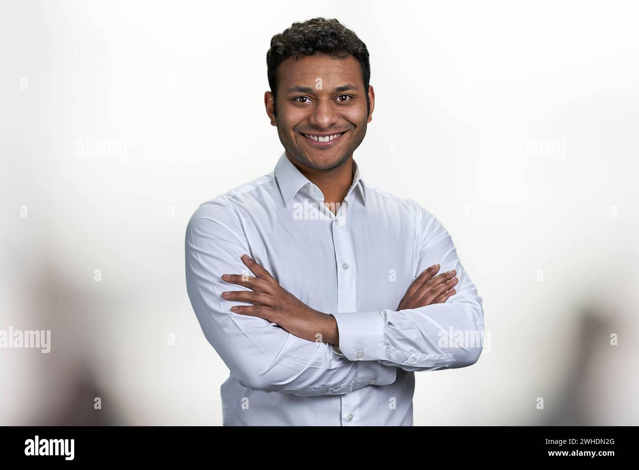 Handsome smiling man with crossed arms looking at camera. Portrait of ...