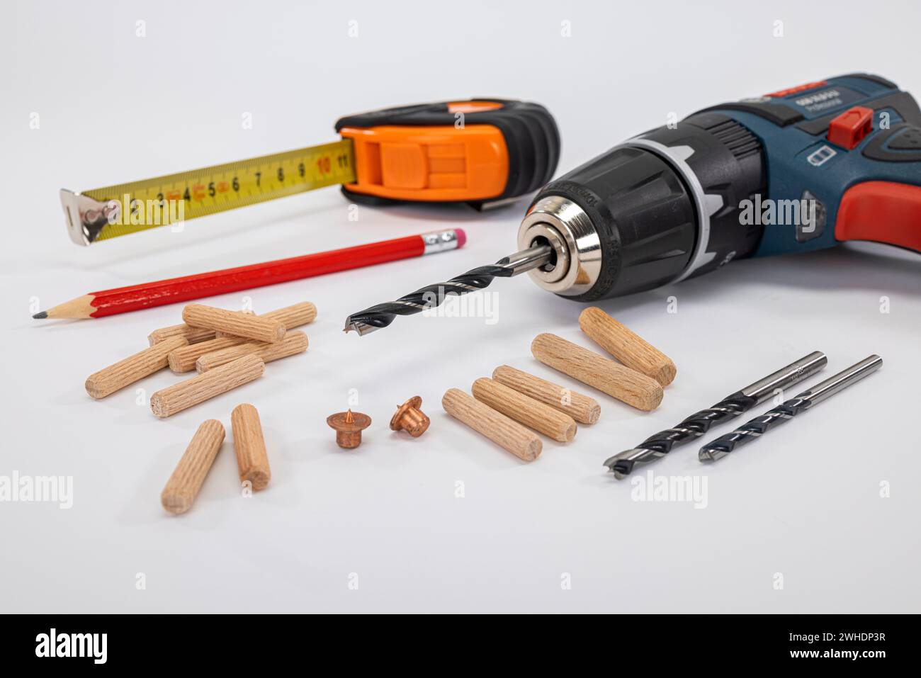 Tools for setting wooden dowels, dowel fixer, wood drill, pencil, tape measure, cordless drill, white background, Stock Photo