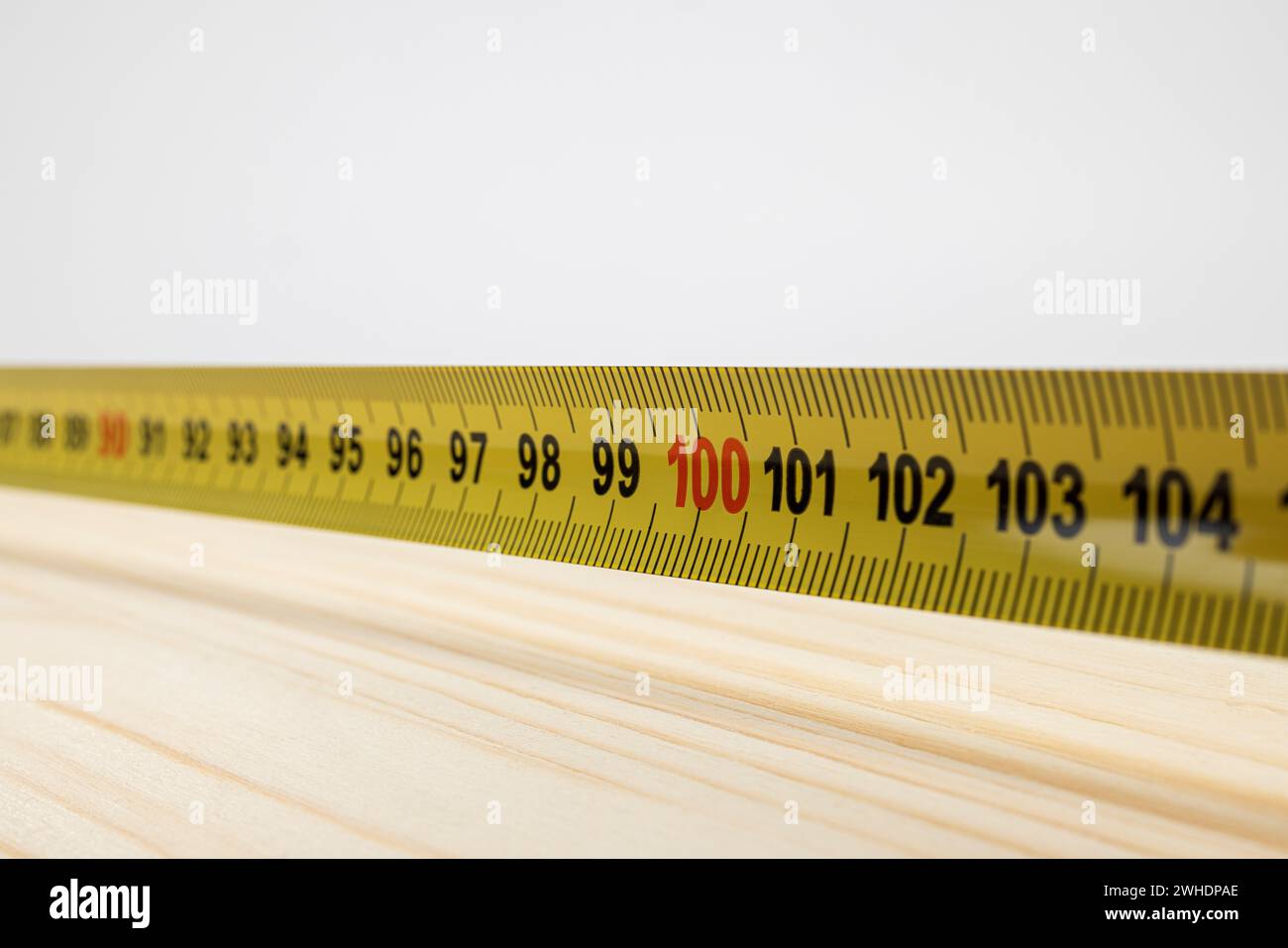 Glued wood panel measure to 100 cm, detail, blur, yellow measuring tape with millimeter and centimeter graduation, Stock Photo