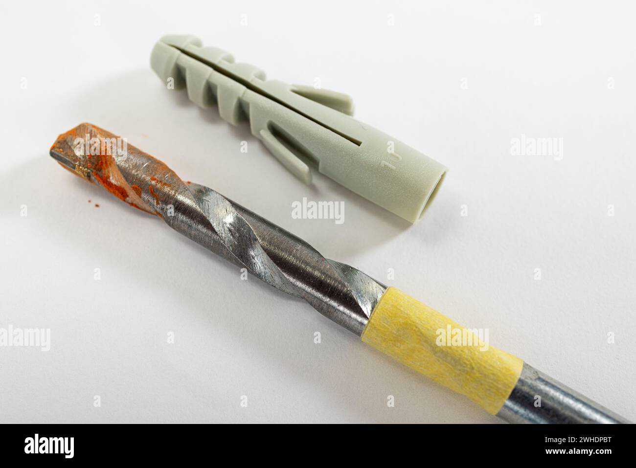 Stone drill marked with masking tape, drill dust, drilling depth for