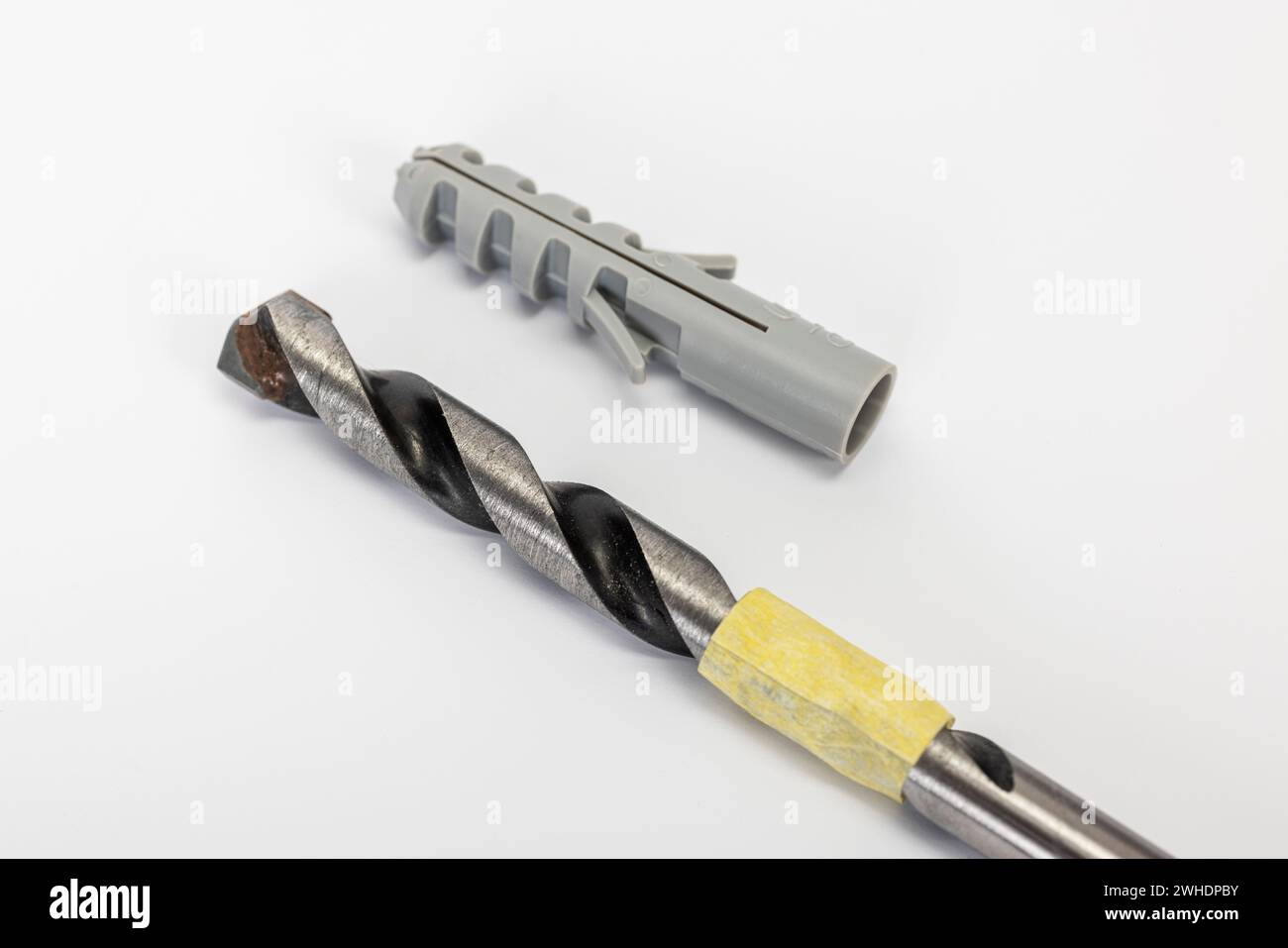 Stone drill marked with masking tape, drilling depth for the adjacent dowel, detail, white background, Stock Photo