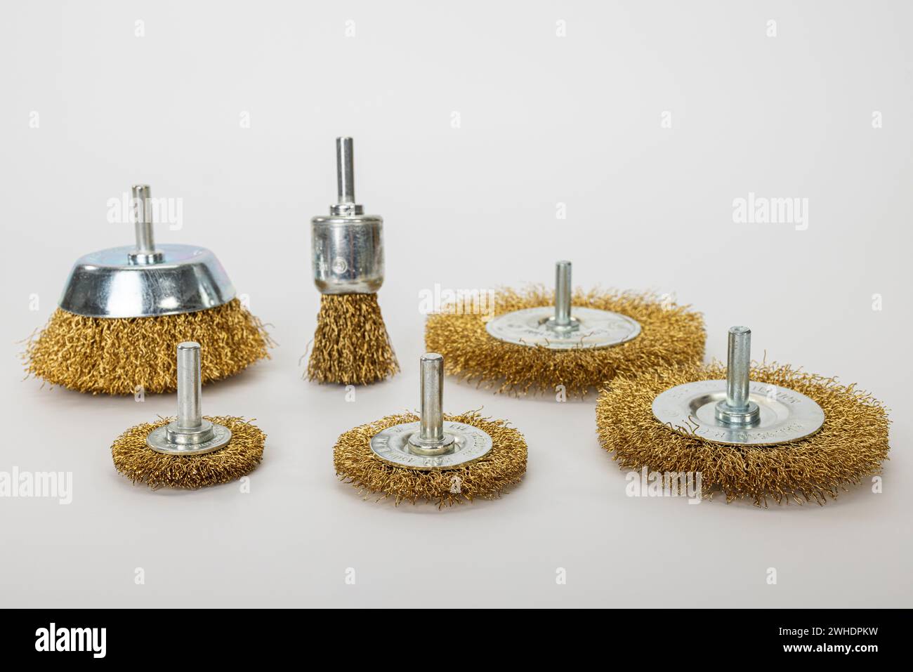 Brass disk brushes, various sizes, for drilling machine, white background, Stock Photo
