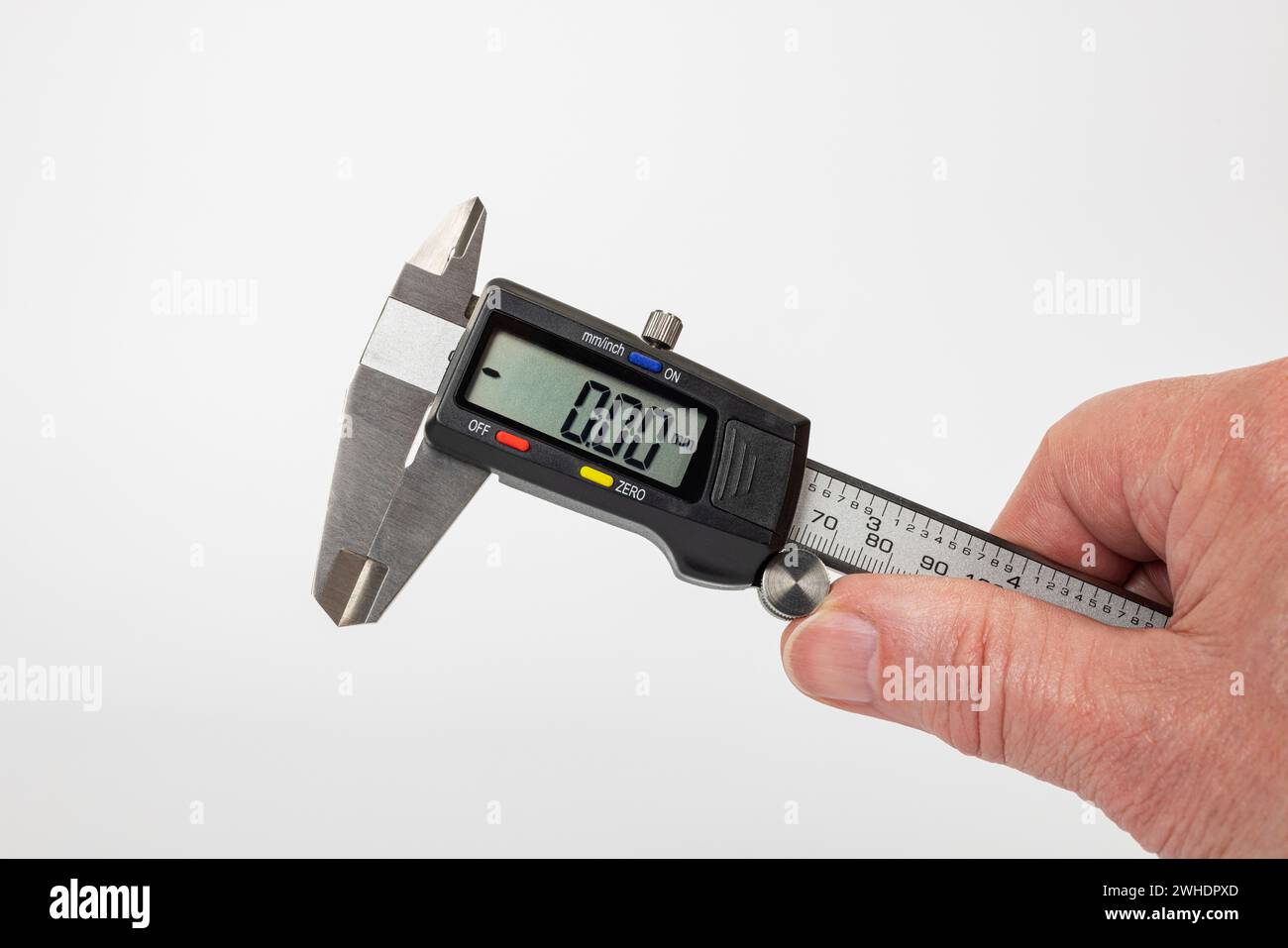 Man's hand holding electronic caliper, display, zero setting, white