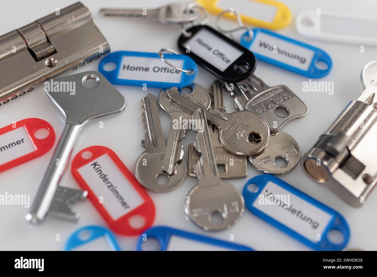 Various keys, key fob with different inscriptions, lock cylinder, detail, white background, Stock Photo