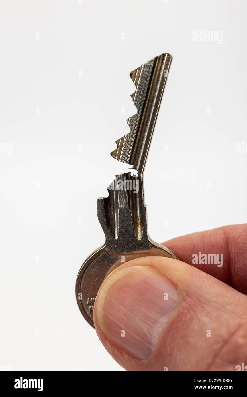 Male hand holding an open door key, cylinder key, white background, Stock Photo