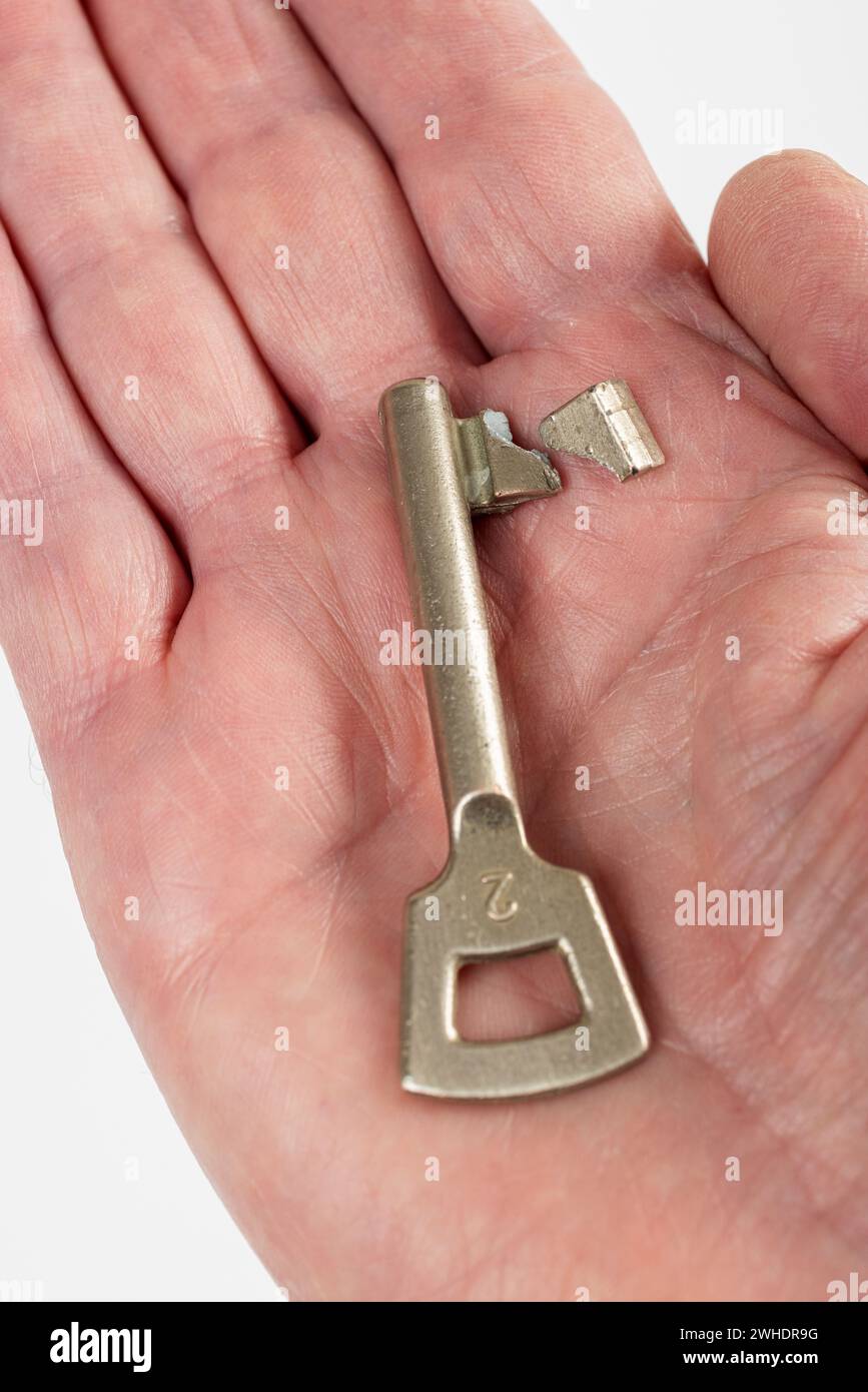 Room door key on a man's palm, colored bar key, white background Stock