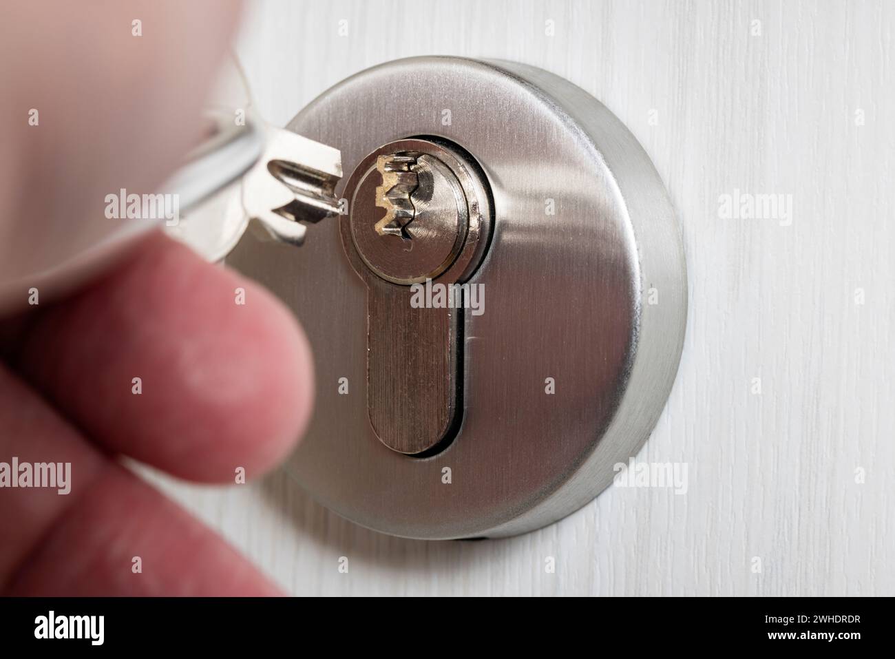 Man's hand holding a broken cylinder key, broken key bit protruding from the cylinder lock, detail, symbolic image, broken apartment key, Stock Photo