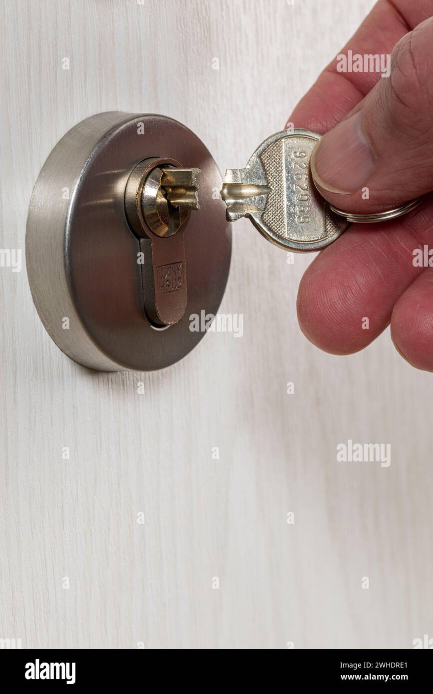 Man's hand holding a broken cylinder key, broken key bit protruding from the cylinder lock, detail, symbolic image, broken apartment key, Stock Photo