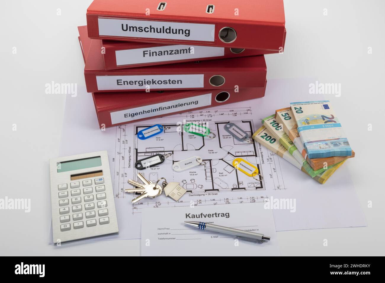 Purchase contract, bunch of keys, different colored key rings, with lettering, floor plan, red file folders with lettering, home financing, energy costs, tax office, debt restructuring, calculator, ballpoint pen, banknotes, bundled, white background, Stock Photo