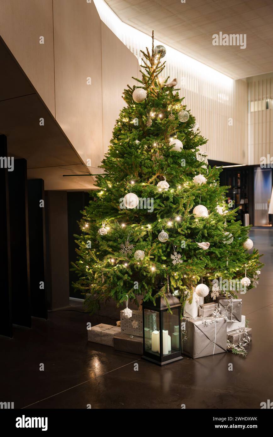 Elegant Christmas Tree Adorned with Warm Lights, Set in a Modern Interior Space Stock Photo