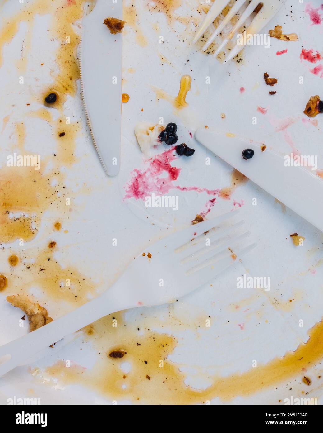 close up of dirty pancake plate with syrup and berries, forks, knives Stock Photo