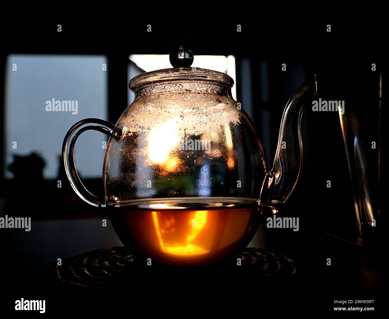 A teapot standing on the countertop, evening sun shining trough Stock Photo