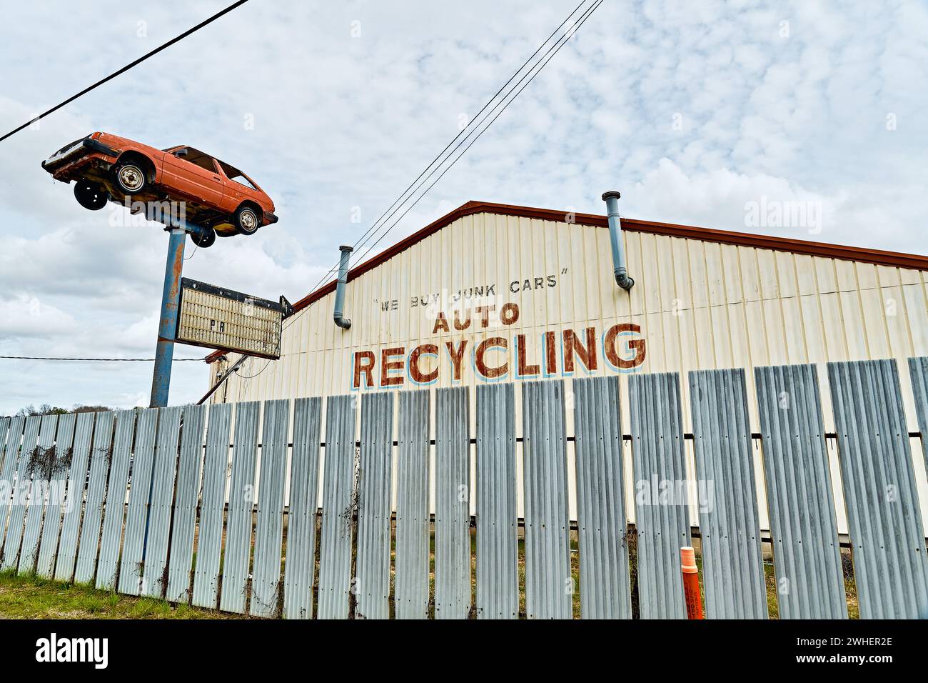 Auto recycling business with a car on a pole in front where junk or junked cars are recycled in Montgomery Alabama, USA. Stock Photo