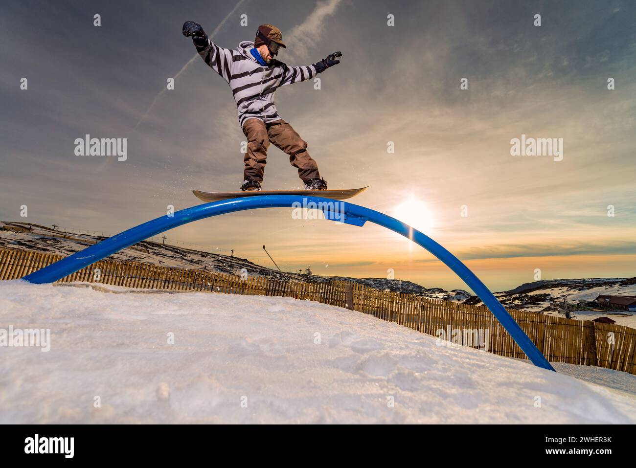 Snowboarder sliding on a rail Stock Photo