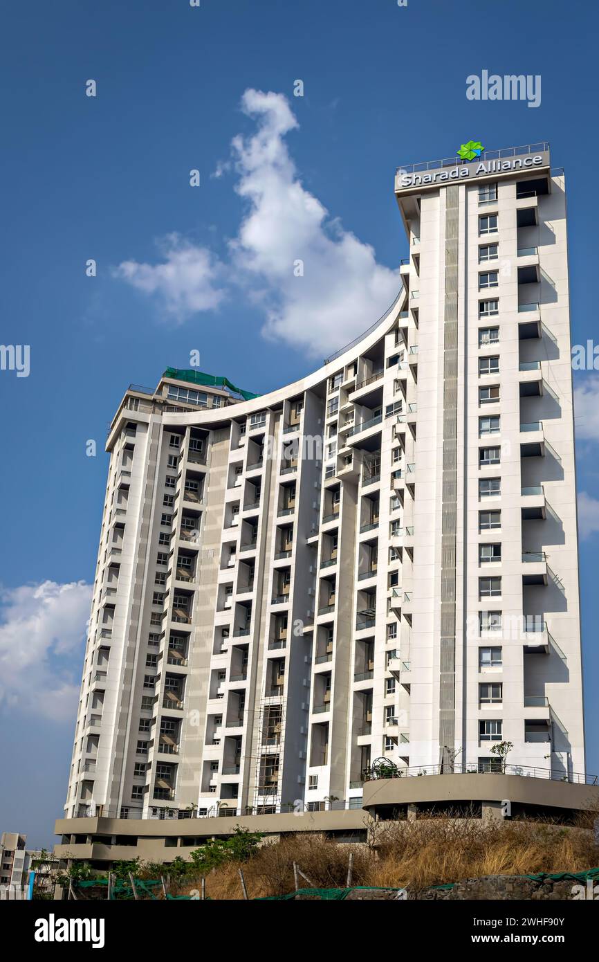 Pune, India-March 19th, 2023:Tall city building with a background of beautiful fluffy blue clouds sky in the background. Stock Photo