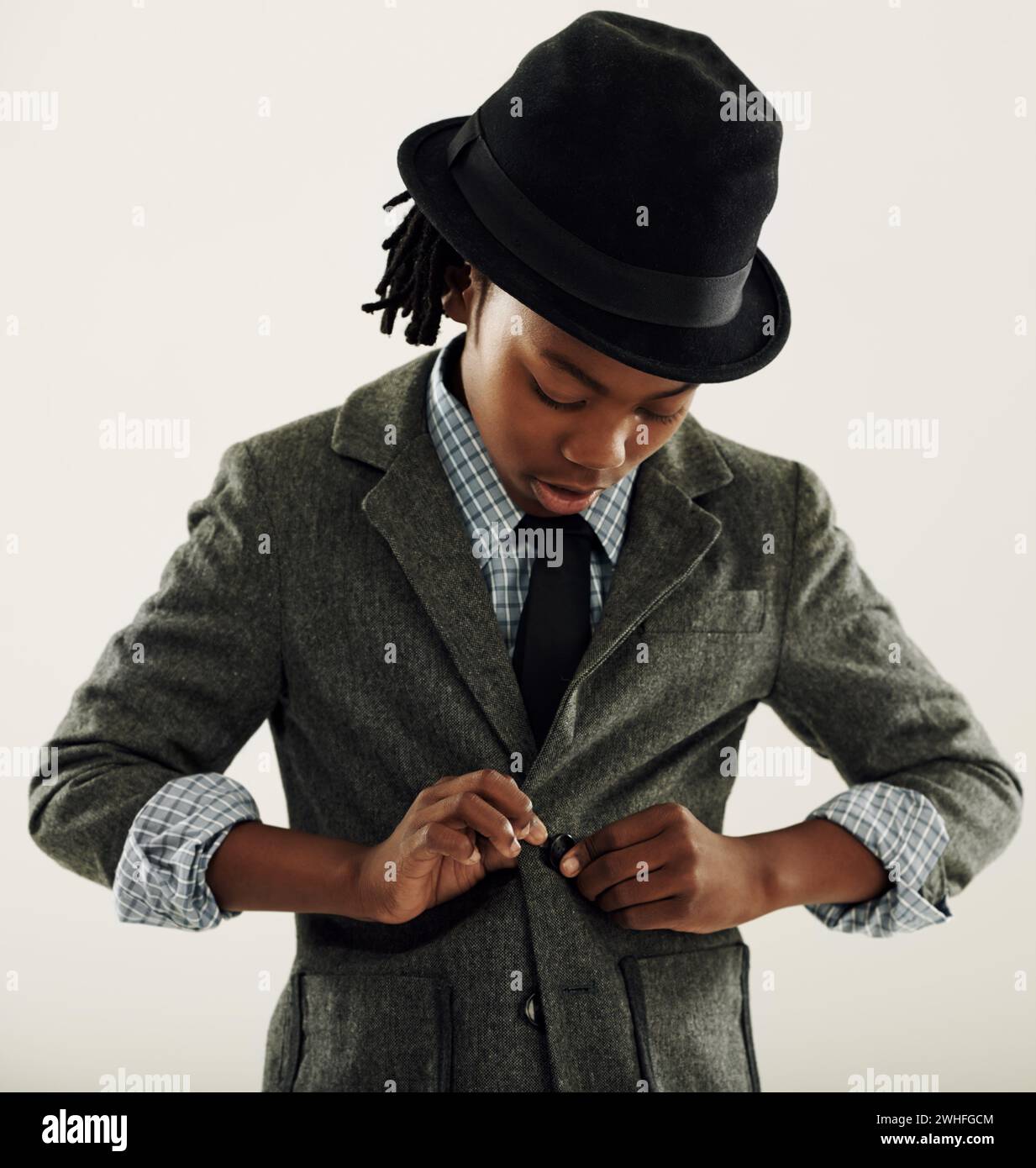 Black child, suit and fashion in studio for vintage style and confidence on a white background. Retro kid or boy check his clothes, coat and fedora Stock Photo