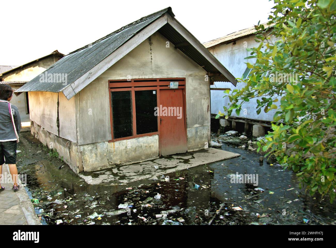 A residential house suffering from land subsidence and coastal flooding in Marunda village, North Jakarta, Jakarta, Indonesia. Stock Photo
