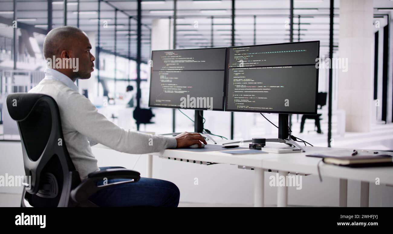 African American Coder Using Computer At Desk. Web Developer Stock Photo