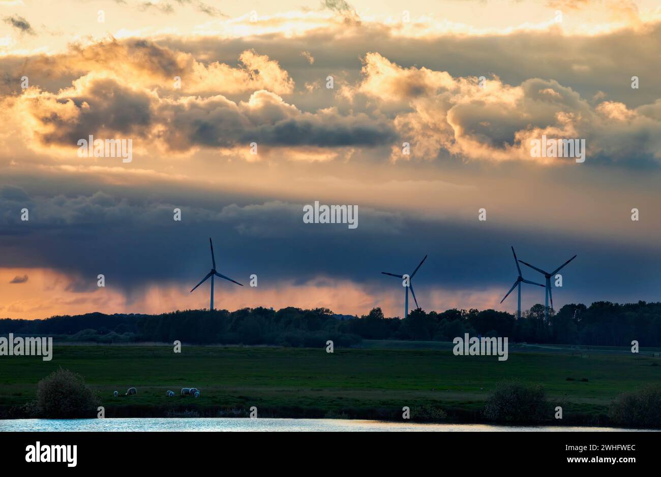 Turbines and dranatic rainy sky at sunset Stock Photo