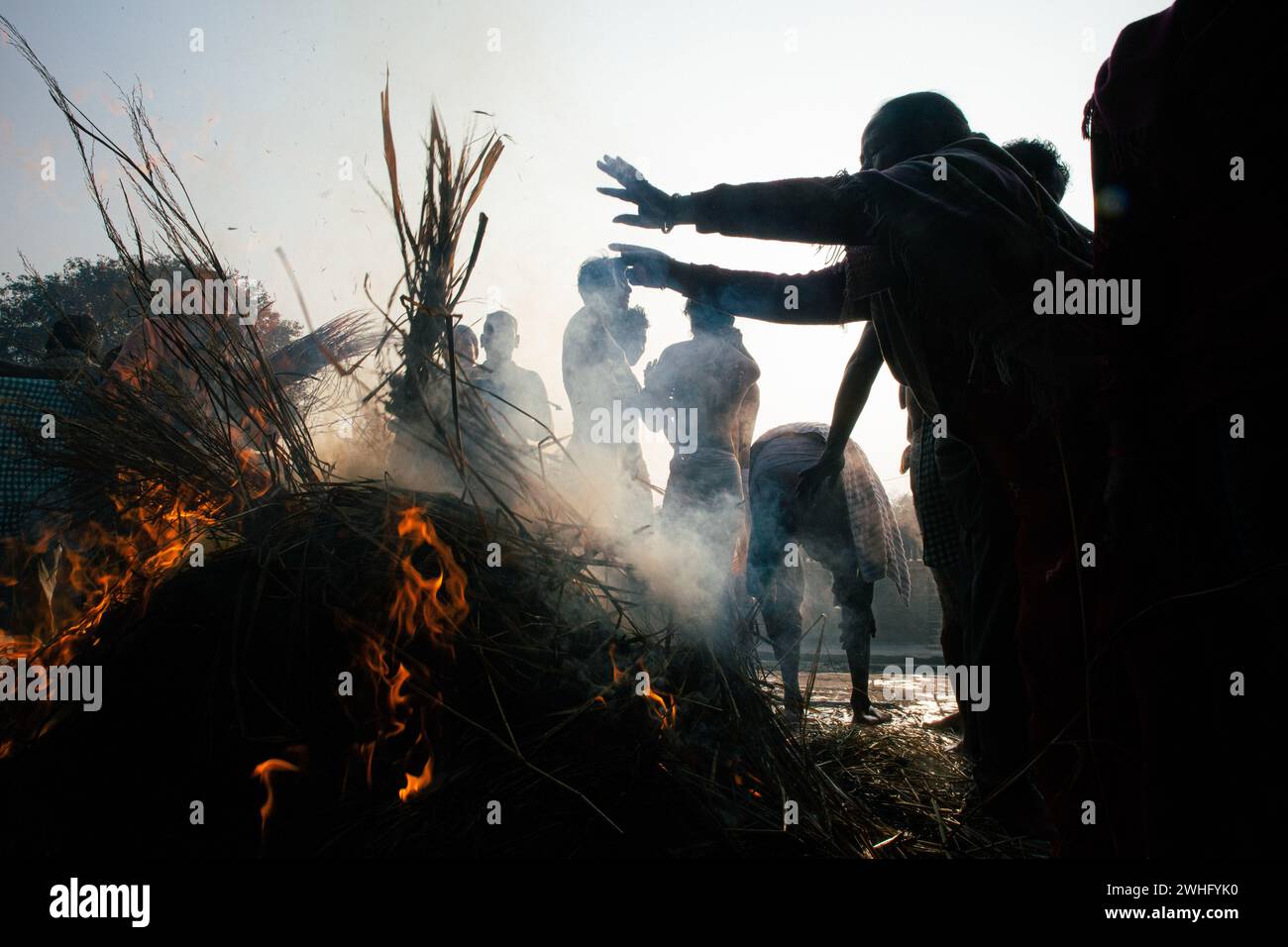 Nepalese Hindu devotees are warming themselves after taking a holy bath during the Madhav Narayan Festival, also known as the Swasthani Brata Katha festival, at the Hanumante River in Bhaktapur, Nepal. The festival is dedicated to God Madhav Narayan and Goddess Swasthani, during which Hindu devotees are recreating and reciting folk tales about miraculous feats performed by them. (Photo by Amit Machamasi/NurPhoto)0 Credit: NurPhoto SRL/Alamy Live News Stock Photo