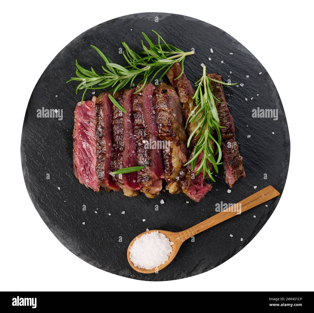Fried piece of beef ribeye cut into pieces on a black board, rare degree of doneness. Delicious stea Stock Photo