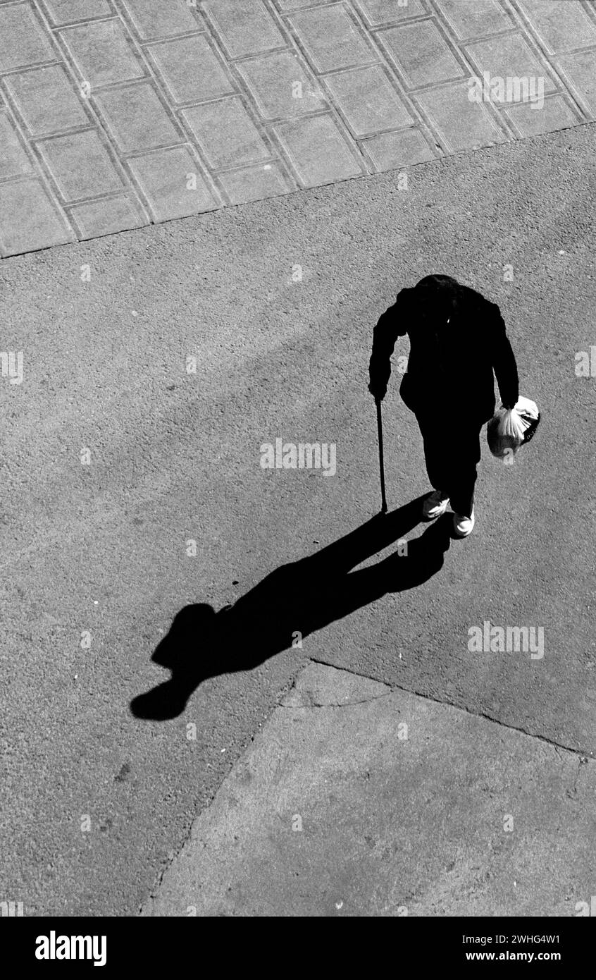 Oldness old people walking on pavement with long shade symbolic oldness Stock ...