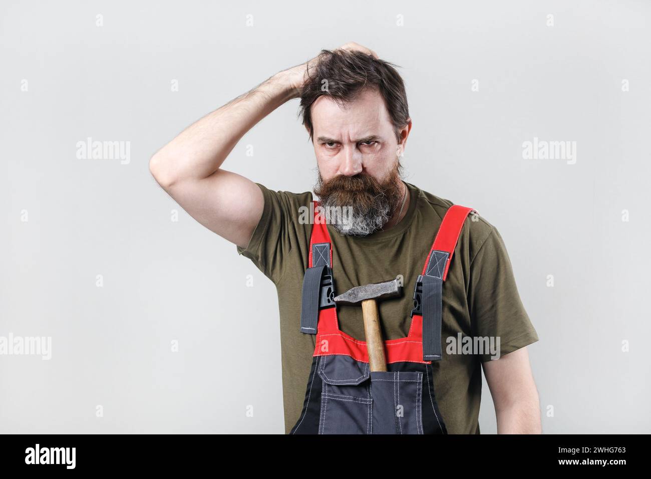 Thoughtful worker in overalls Stock Photo