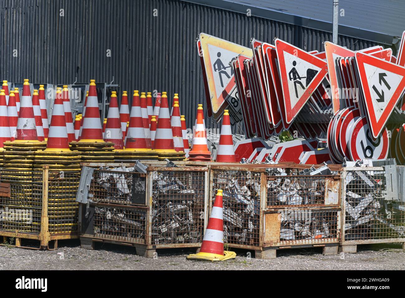 Traffic cones or pylons and signs for road construction sites on an outdoor storage area, selected focus Stock Photo