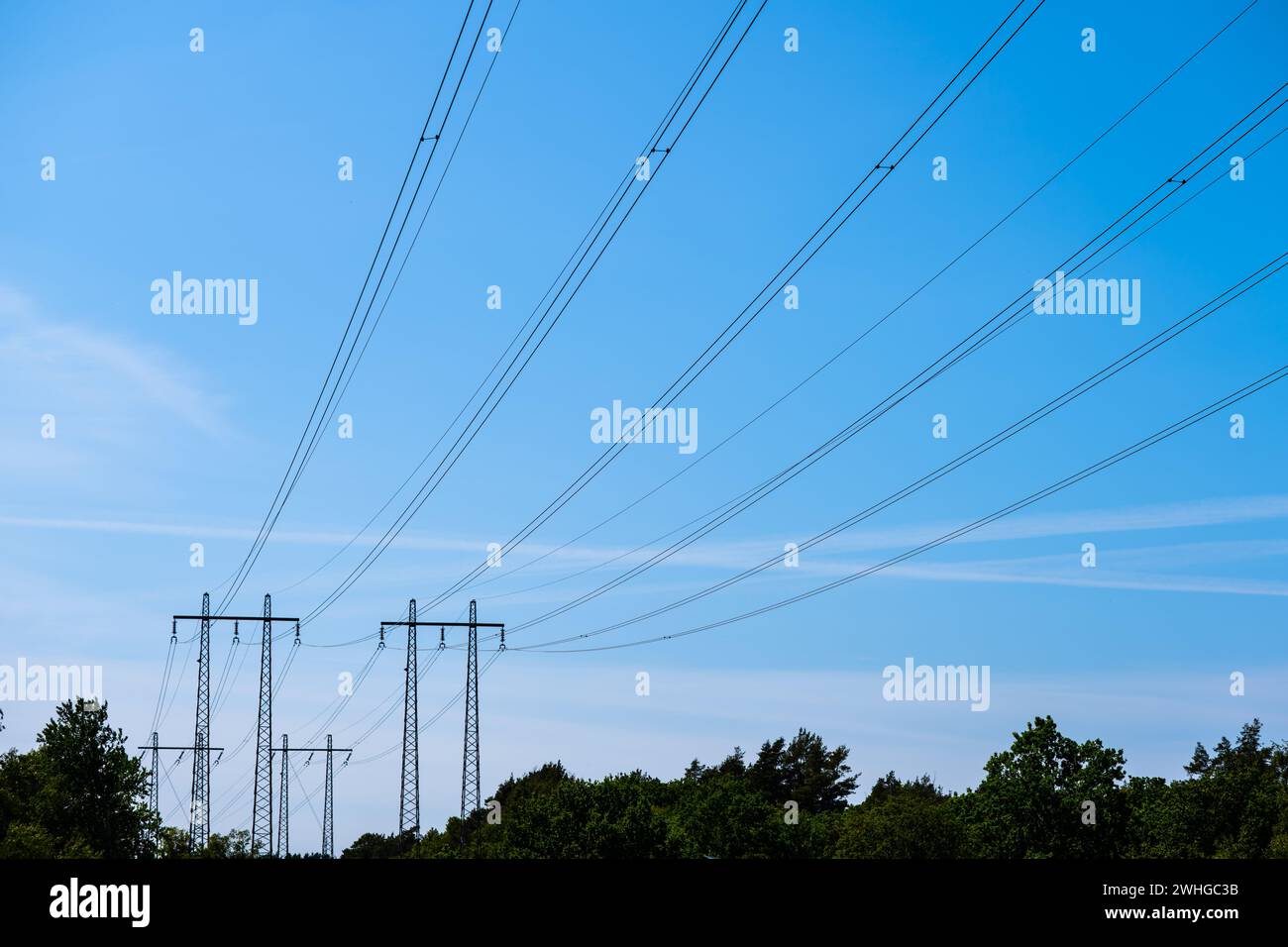 High voltage power lines passing over a forest Stock Photo - Alamy