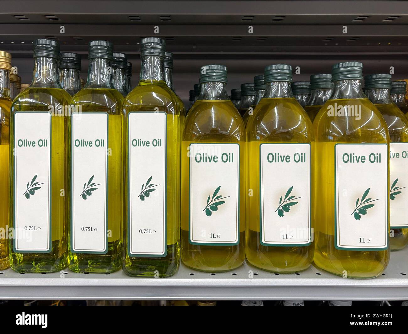 Olive oil in one-liter and 750-ml glass bottles on the shelf Stock ...