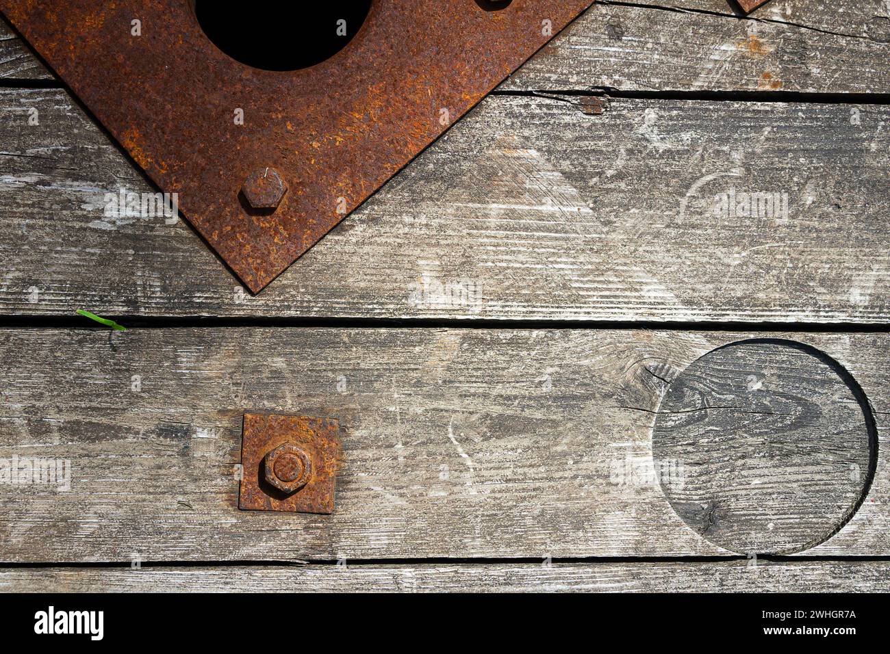 An old and cracked wooden panels with rusty nut and bolt in it as a background Stock Photo