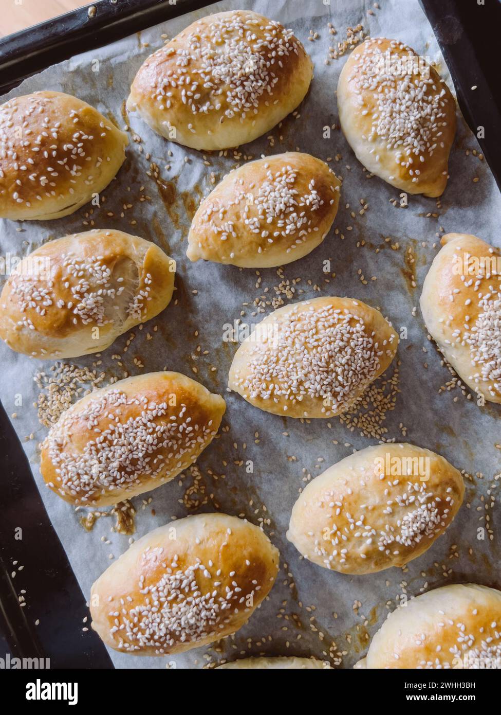 Freshly baked sesame buns lie on a baking sheet Stock Photo