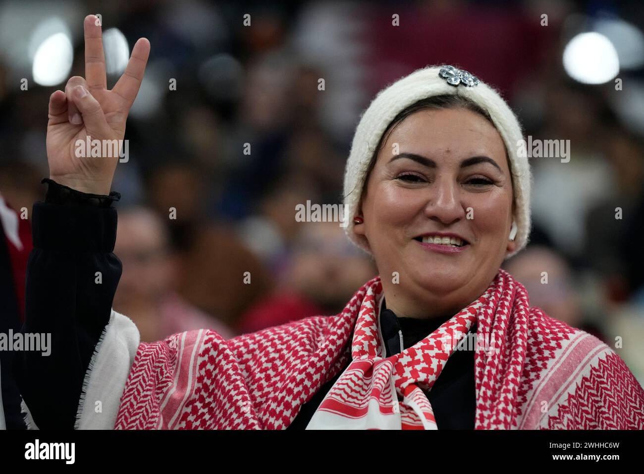 A supporter flashes v-sign as she cheers before the Asian Cup final ...