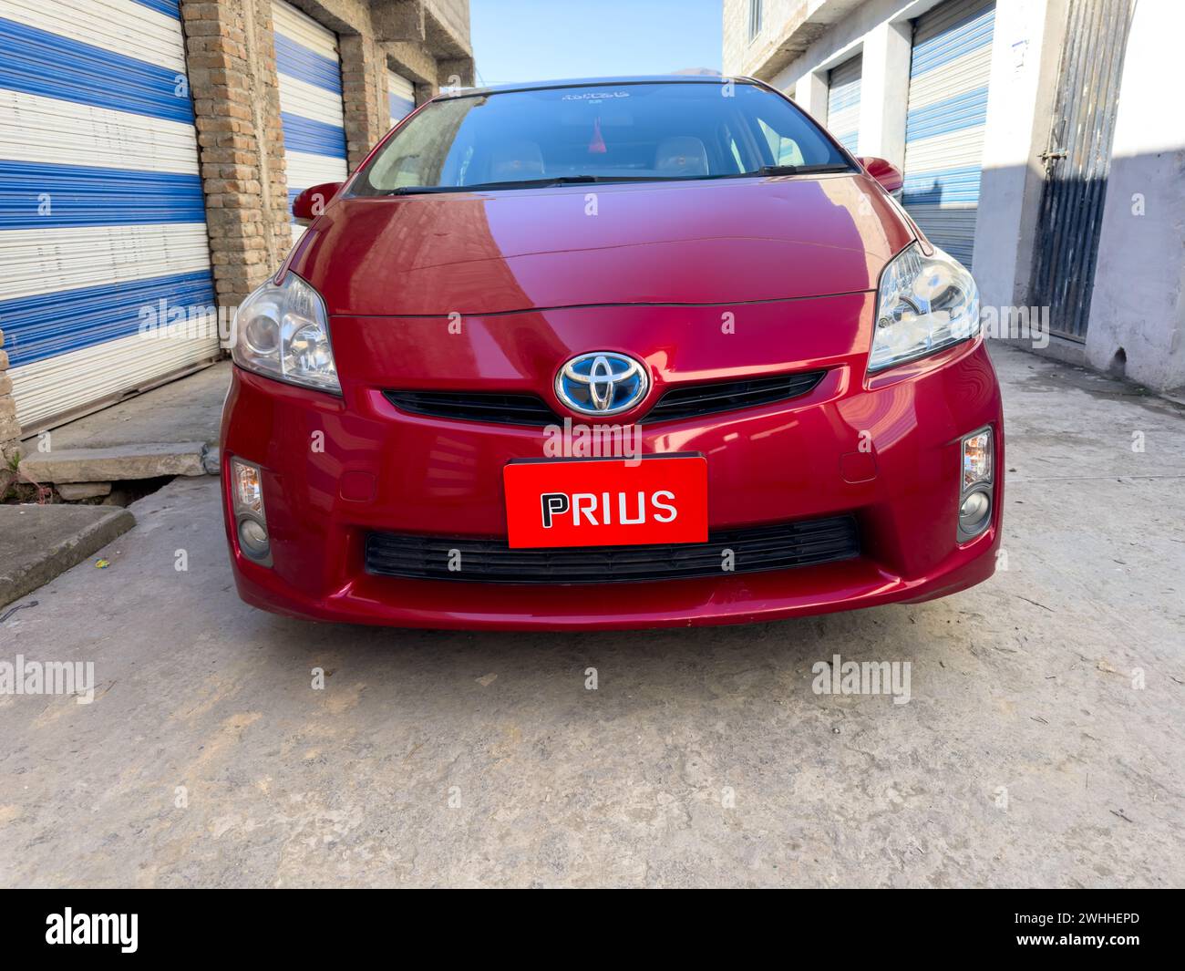Red Toyota Prius car closeup view. Fuel-Efficient transportation concept: Swat, Pakistan - 08 Feb 2024. Stock Photo