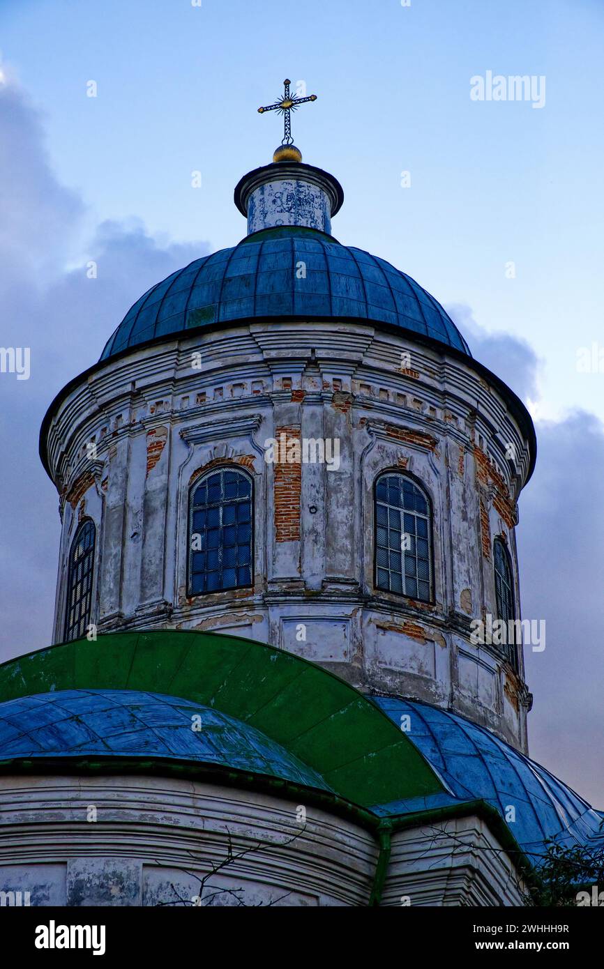 The image shows a weathered dome of a church with a cross on top, under ...
