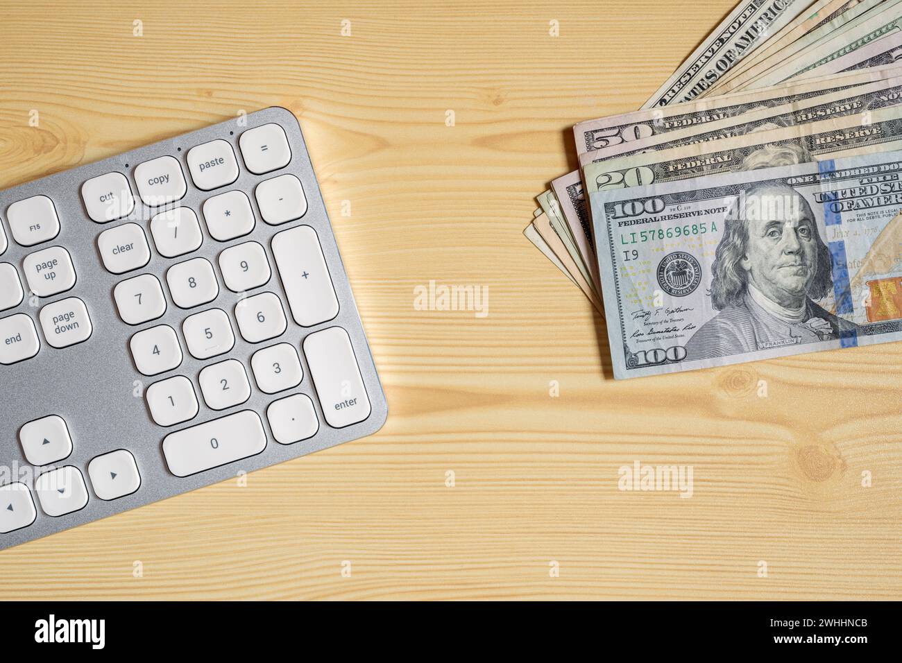 Desktop PC computer keyboard and American Dollar currency banknotes on office desk, top view Stock Photo
