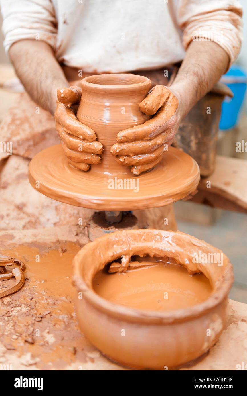 Potter working the clay with hands isolated in the foreground Stock Photo