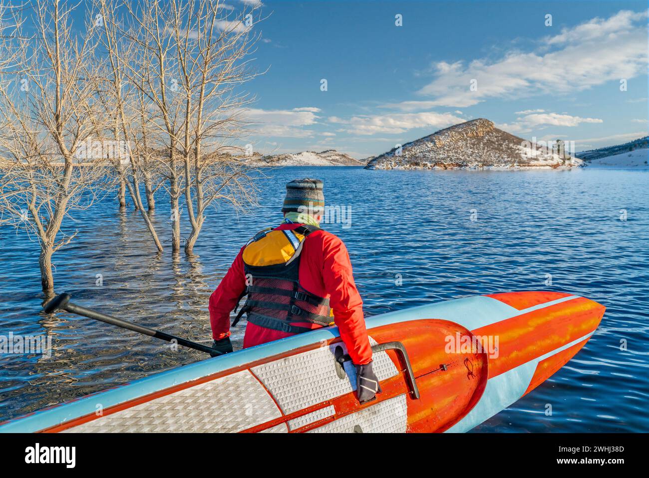 male paddler wearing a drysuit, life jacket and safety leash is starting workout on a long