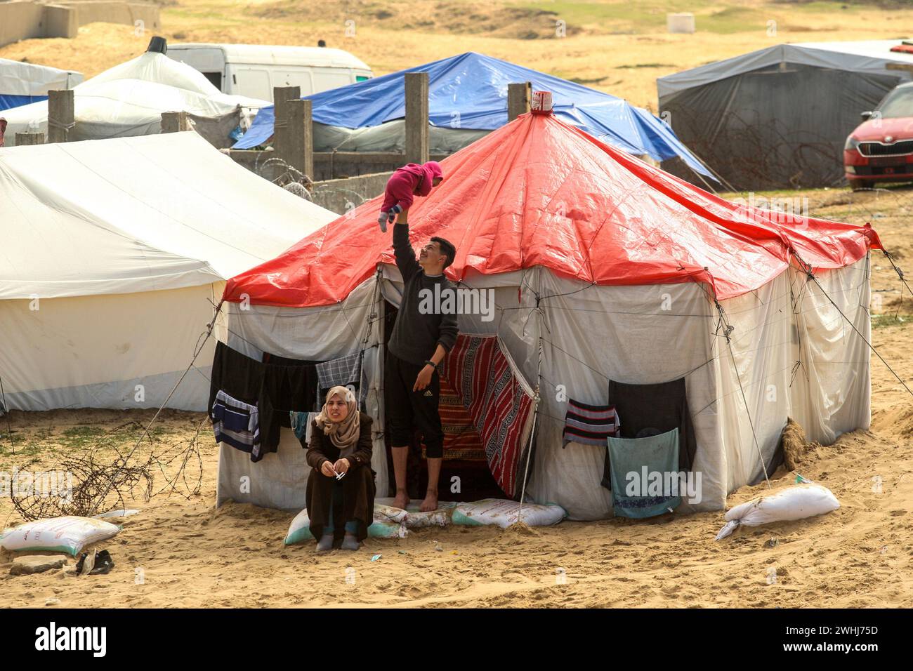 Rafah, Gaza. 10th Feb, 2024. Displaced Palestinians sit in front of a makeshift tent as Palestinian families seek shelter in the Mawasi area as they struggle to find clean water, food and medicine as Israeli attacks continue in Rafah, Gaza, Saturday, February 10, 2024. Photo by Ismael Mohamad/UPI Credit: UPI/Alamy Live News Stock Photo