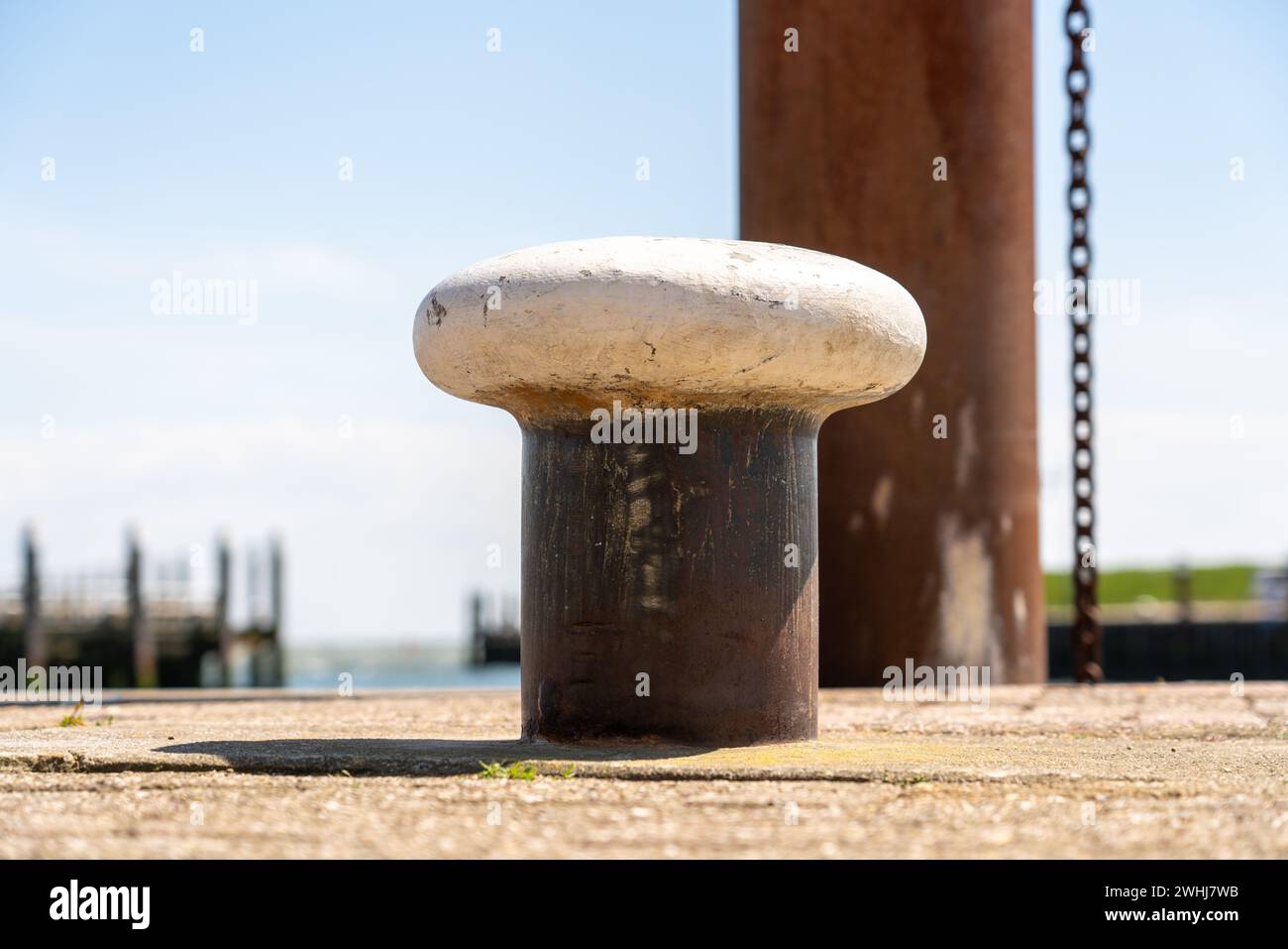 A bollard at the port of the Netherlands where the boats can be anchored and that is out of iron Stock Photo