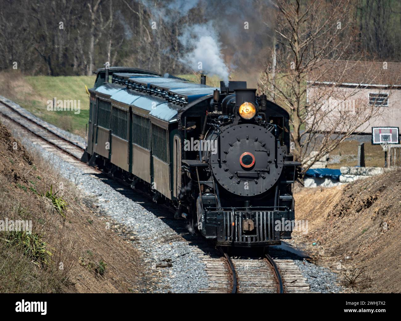Front and Slightly Above View Approaching Restored Narrow Gauge Passenger Steam Train Blowing Smoke Stock Photo